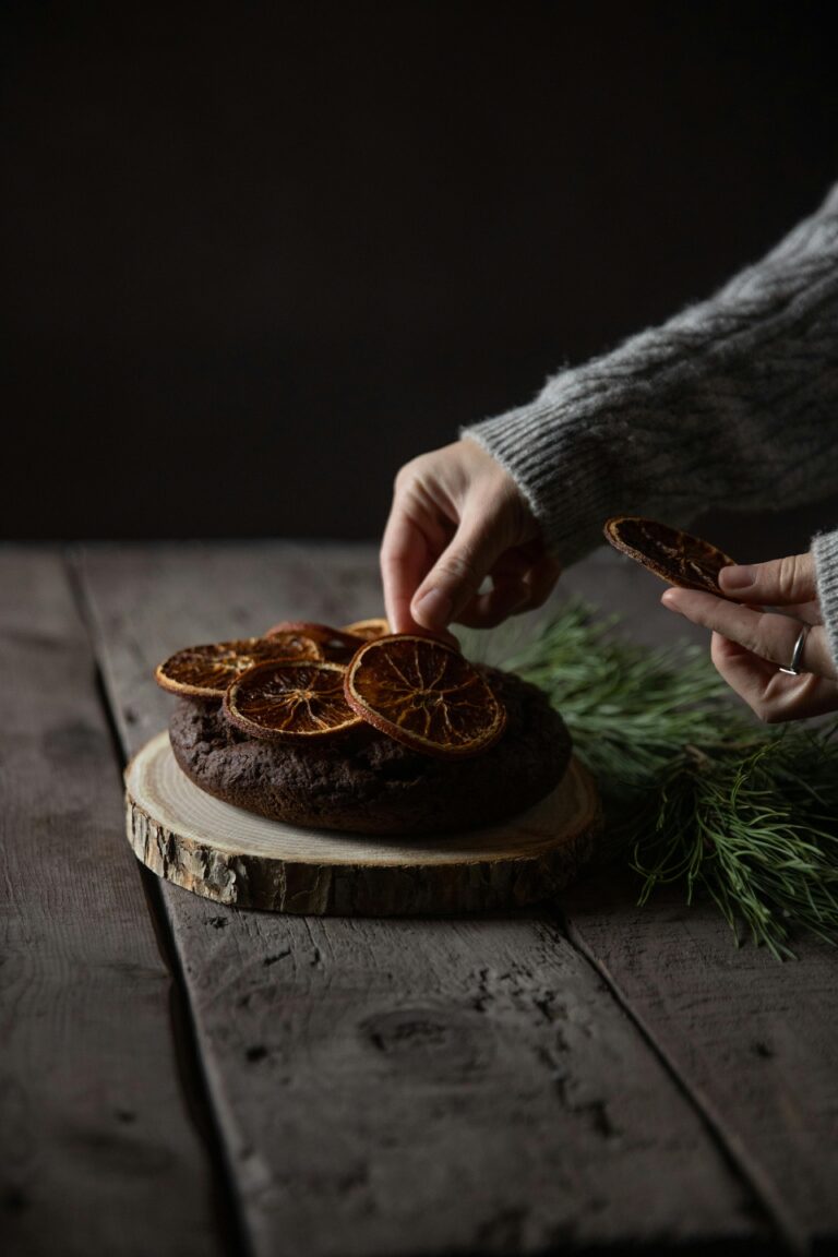 Woman Putting Dry Orange Slices on a Wooden Table