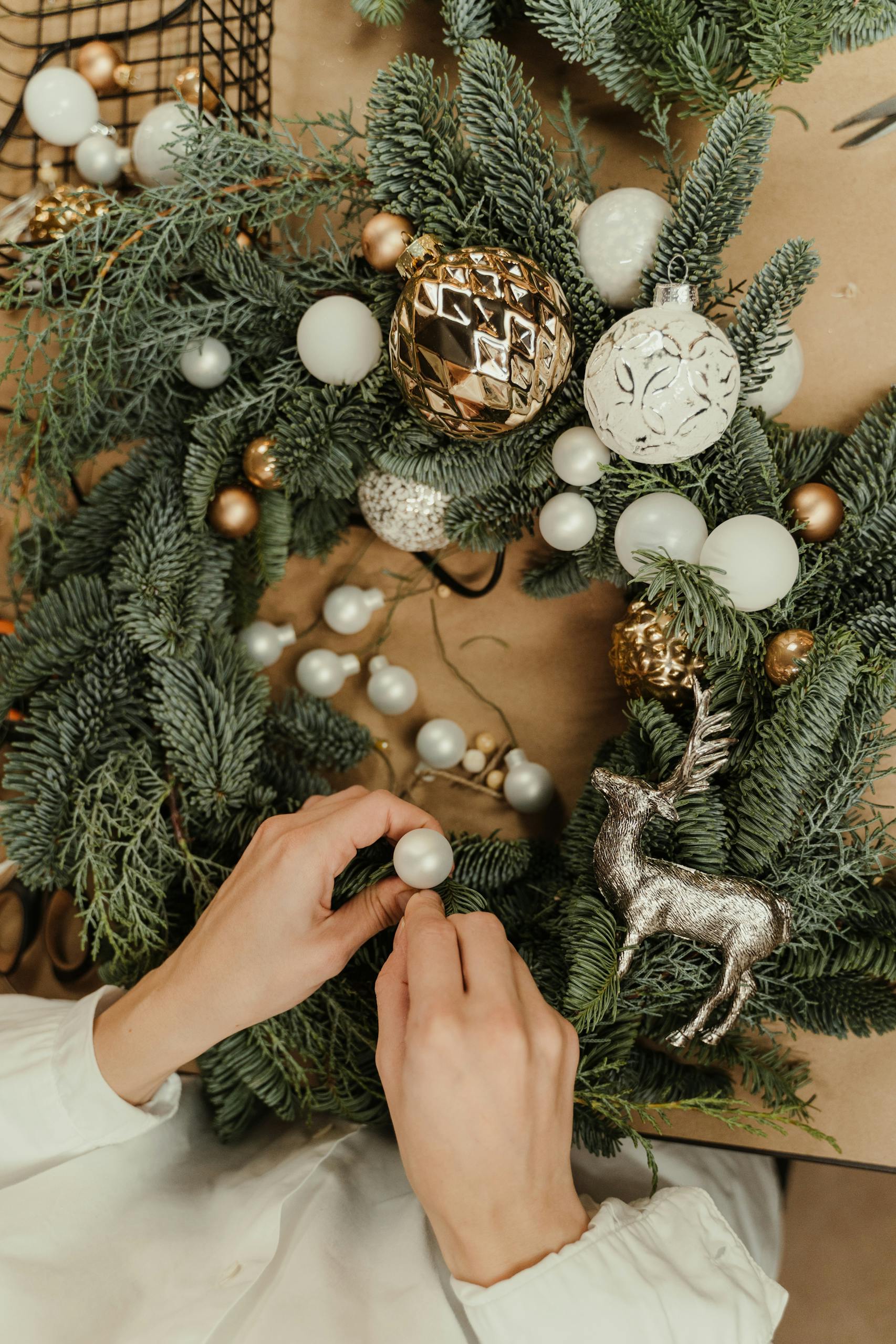 A festive Christmas wreath adorned with baubles and a silver reindeer, crafted by hand.