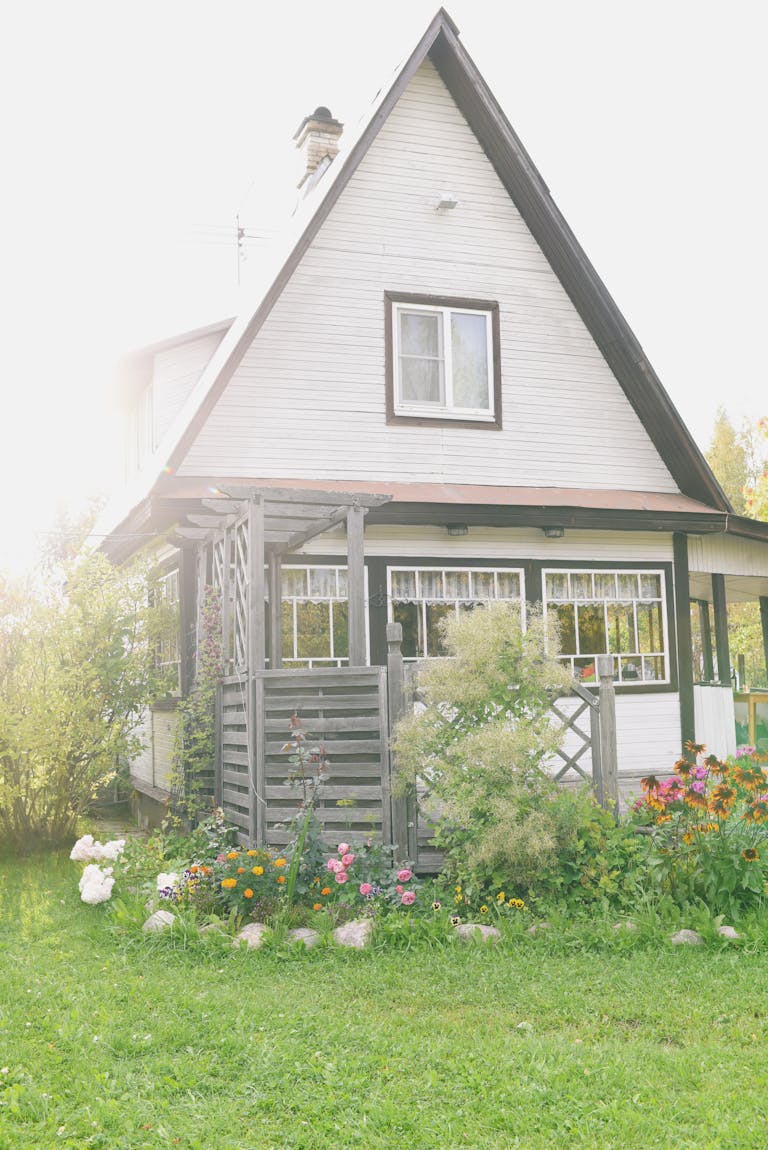 Idyllic rustic cottage with lush garden under bright sunlight, perfect for tranquility seekers.