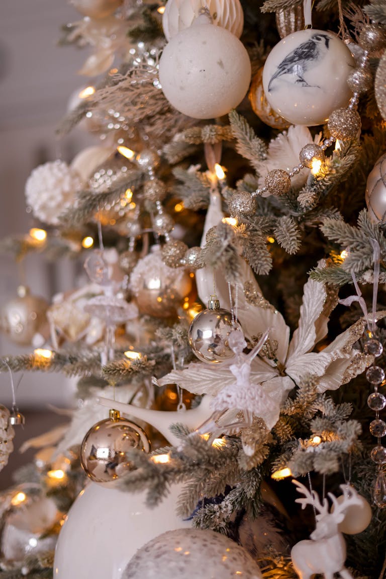 Regal Christmas tree adorned with gold and white decorations, featuring lights, baubles, and elegant ornaments.