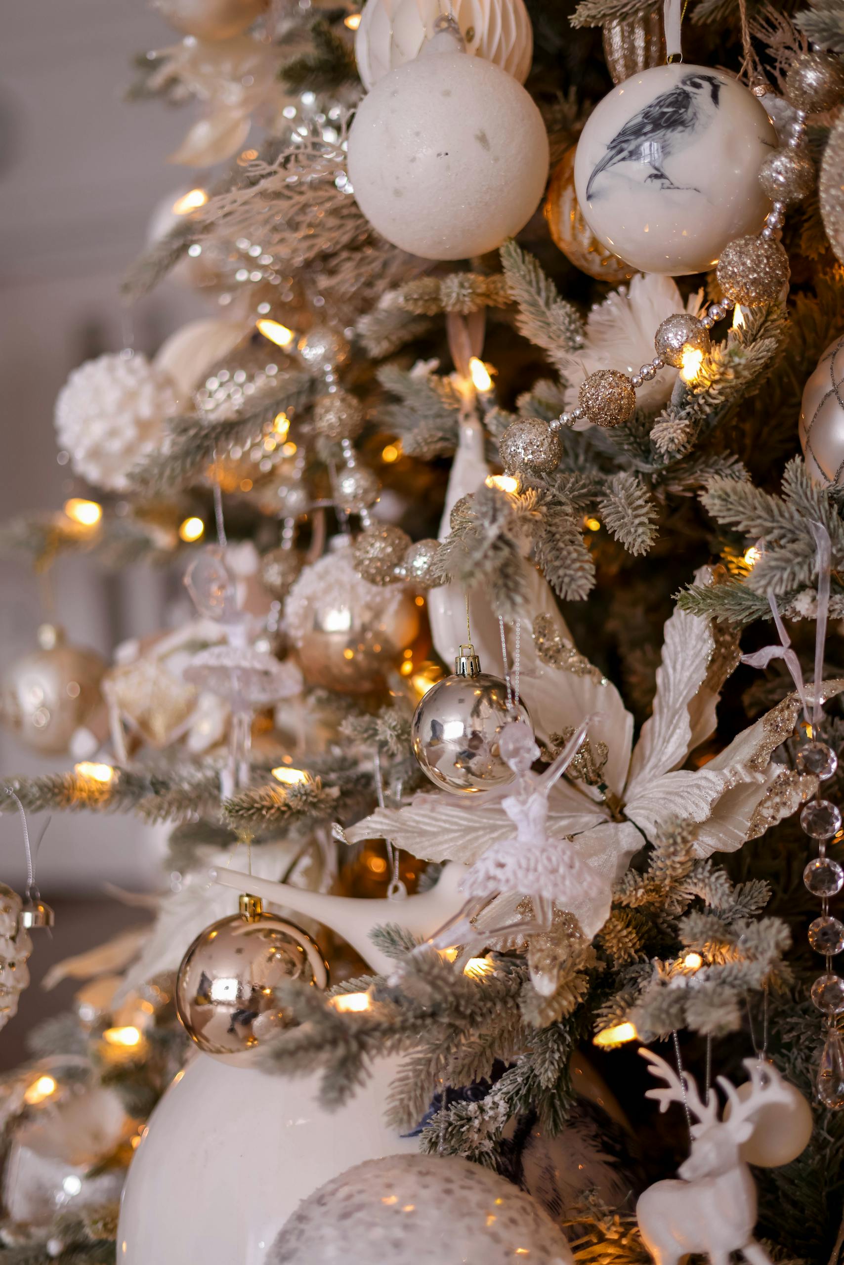 Regal Christmas tree adorned with gold and white decorations, featuring lights, baubles, and elegant ornaments.