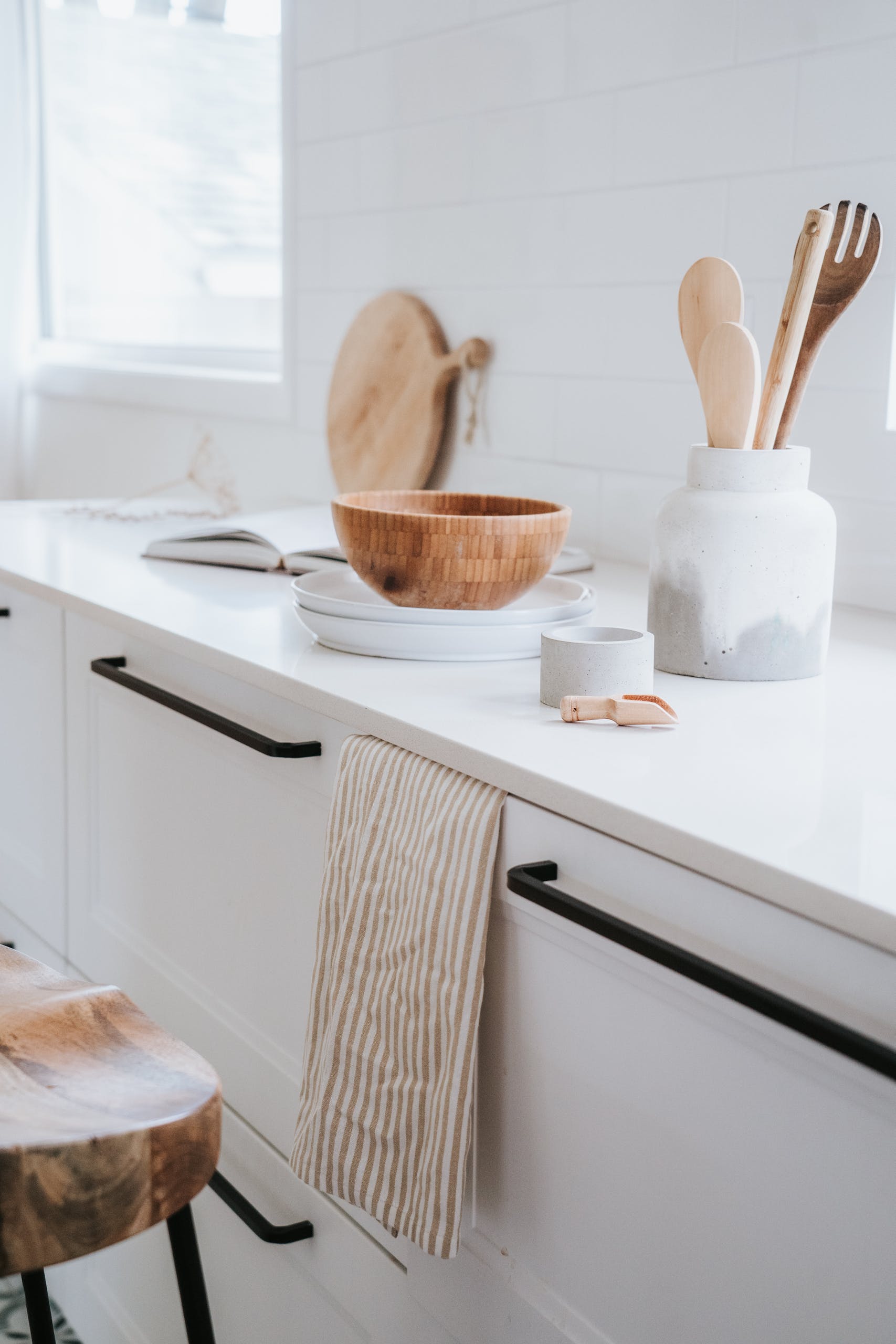 A beautifully minimalist Japandi style kitchen with wooden utensils, ceramics, and a bright, airy feel.