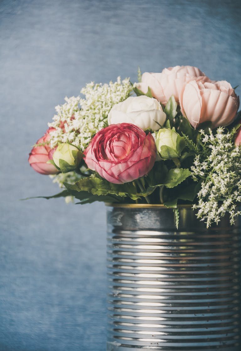 A delicate bouquet of flowers beautifully arranged in a rustic silver can, perfect for decor.